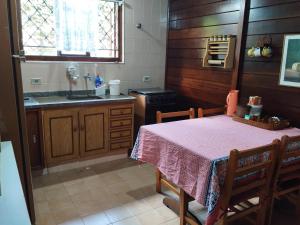 a kitchen with a table and a sink and a stove at Casa campos recanto in Campos do Jordão +48 photos