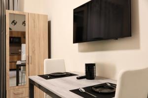 a room with a table with chairs and a flat screen tv at Luxe Living Studio in Tirana +49 photos