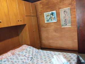 a bedroom with a bed and a brick wall at Casa campos recanto in Campos do Jordão