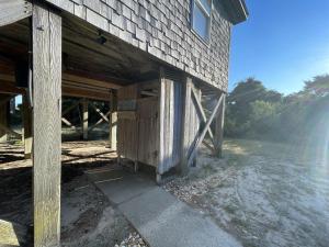 a wooden barn with a door on the side of it at CHASING SUNSETS cottage in Hatteras