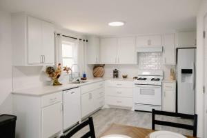 a white kitchen with white appliances and a table at The Rustic Roost in Abilene