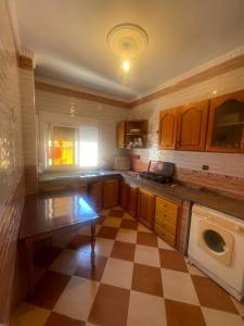 a large kitchen with a checkered floor at VERSE 5 min de la playa in Riffiene