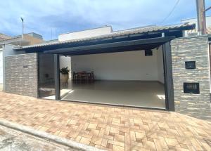 un garage con tenda da sole su un edificio in mattoni di Casa confortável, Temporada Votuporanga a Votuporanga