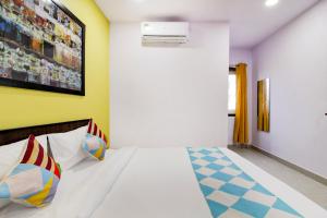 Hotel O PRAMOD PRIME HOMES في Surūrnagar: غرفة نوم مع سرير مع avertisement for avertisementosateosateosateosateosate