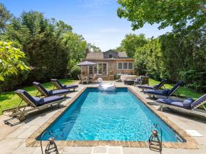 une piscine avec des chaises longues et une maison dans l'établissement 1800 Historical East Hampton Home, 1 Mile to Town!, à East Hampton