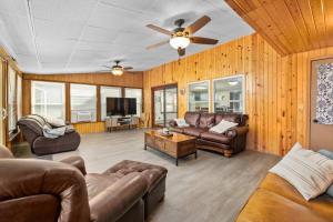 a living room with leather furniture and a ceiling fan at Family-Friendly Lakehouse with Firepit and Dock in Warsaw