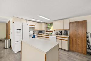 an empty kitchen with white appliances and wooden cabinets at Family-Friendly Lakehouse with Firepit and Dock in Warsaw
