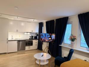 a kitchen with white cabinets and a table in a room at Noah Longstay Nordhemsgatan 23 in Gothenburg
