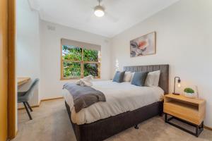 a bedroom with a bed and a desk and a window at Cozy Newtown 2 bedroom unit in Geelong