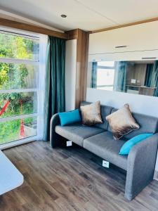 a living room with a couch and a window at Hilltop Tiny Escape Stunning Harbour & City Views in Wellington