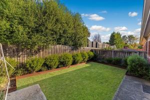 a garden with a wooden fence and green grass at Cozy Newtown 2 bedroom unit in Geelong