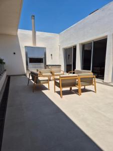 a patio with benches and a fireplace on a building at Houze 208 in Asuncion