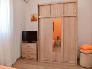 a large wooden cabinet with a mirror in a bedroom at One Bedroom Apartment with Terrace & Garden View in Supetar