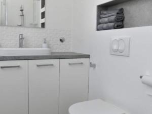 a white bathroom with a sink and a toilet at One Bedroom Apartment with Terrace & Garden View in Supetar +7 photos