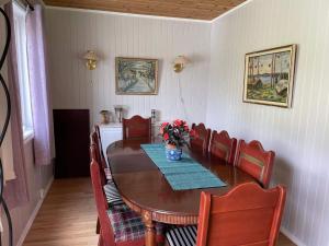 a dining room table with chairs and a vase of flowers on it at 7 person holiday home in Grovfjord in Kovan