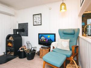 un soggiorno con sedia e camino di Nature Cottage with Terrace by Gudena a Roe