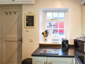 a kitchen with a counter top and a window at Staffield Cottage in Kirkoswald