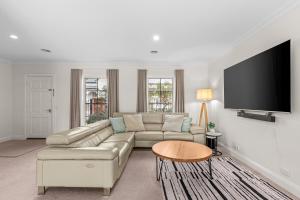 ジーロングにあるThe Geelong Getaway Townhouseのソファと薄型テレビのあるリビングルーム