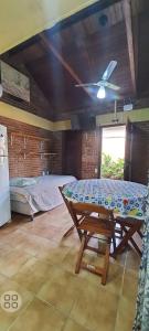 um quarto com uma cama, uma mesa e uma ventoinha de tecto em Chales praias de Ubatuba em Ubatuba
