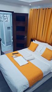 a bedroom with two beds with orange pillows at Room at Arthur Resort in Legazpi +11 photos
