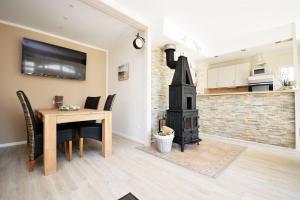 eine Küche und ein Esszimmer mit einem Tisch und einem Kamin in der Unterkunft Aalreuse in Südbrookmerland