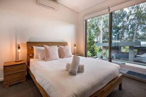 a bedroom with a large bed and a large window at Sunrise Tranquillity - Luxe Retreat with Heated Spa in Yallingup Siding