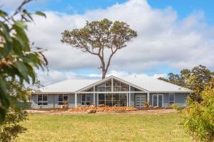 ein Haus mit einem Baum davor in der Unterkunft Skibo House - A Family Retreat near Margaret River in Witchcliffe