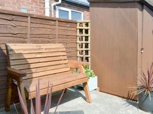 un banco de madera sentado junto a una valla en Say Shells, en Filey
