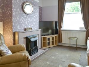 Una sala de estar con chimenea y televisión. en Say Shells, en Filey