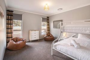 ein Schlafzimmer mit einem weißen Etagenbett und einem Fenster in der Unterkunft Skibo House - A Family Retreat near Margaret River in Witchcliffe