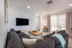 a living room with a couch and a table at Reverie By The Bay - Walk to Beaches, Relax in Style in Dunsborough