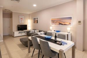 a living room with a table and a couch at Surfside 3A - Vibrant Yallingup Beachfront Living in Yallingup