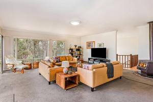 un salon avec deux canapés et une télévision dans l'établissement The Nest - Tranquil Bush Retreat near Dunsborough, à Yallingup Siding