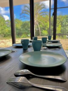 una mesa de madera con platos y cubiertos en 川平湾から車で10分シアター付きシークレットシーサー, en Ishigaki Island 16 fotos más