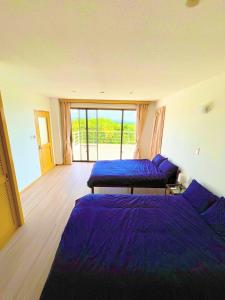 Un dormitorio con dos camas y una gran ventana. en 川平湾から車で10分シアター付きシークレットシーサー, en Ishigaki Island