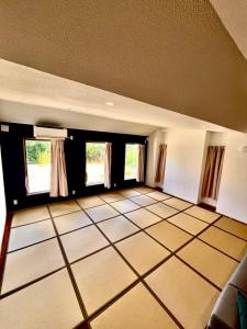 Habitación grande con suelo de baldosa blanca y ventanas. en 川平湾から車で10分シアター付きシークレットシーサー, en Ishigaki Island
