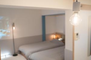 Ένα ή περισσότερα κρεβάτια σε δωμάτιο στο Blue Nest Takamatsu