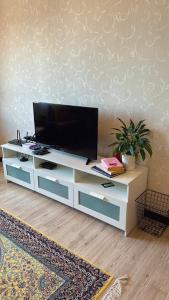a living room with a tv on a white entertainment center at At Sky Palace Kuala Terengganu in Kuala Terengganu