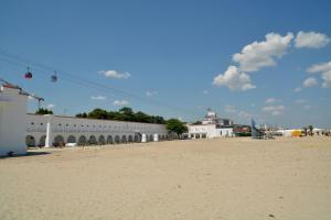 a building on the beach next to a sandy beach at Hostel Cazino Sud in Mamaia
