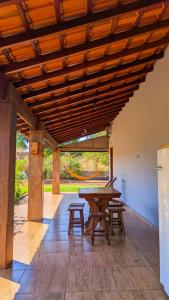 a wooden pavilion with a picnic table and benches at Pousada Rancho Dona Lú Solo in Pereira Barreto
