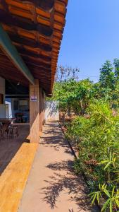 a walkway leading to a house with a wooden roof at Pousada Rancho Dona Lú Solo in Pereira Barreto