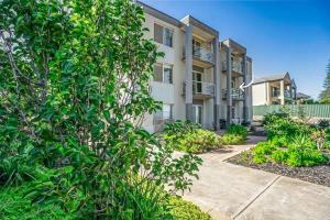 an apartment building with a tree in front of it at Beachfront self contained upstairs apartment in Semaphore