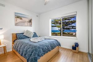 a bedroom with a bed and a window at Beachfront self contained upstairs apartment in Semaphore