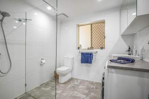 a bathroom with a toilet and a glass shower at Beachfront self contained upstairs apartment in Semaphore +37 photos