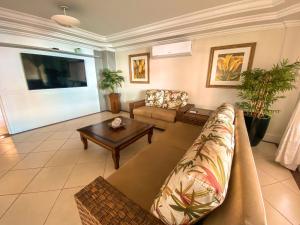 a living room with a couch and a table at Pousada Vila do Coral in Bombinhas