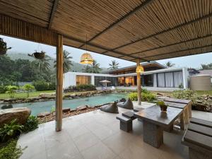 an outdoor patio with a table and a pool at Villa harmony haven in Taling Ngam in Ban Khok Kroat