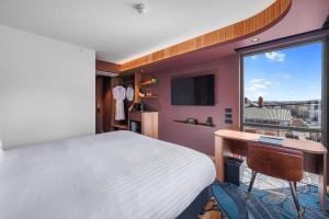a bedroom with a bed and a desk and a window at George Hotel Launceston, an Ascend Collection Hotel in Launceston