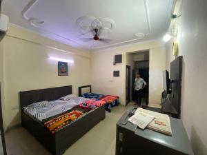 a bedroom with a bed and a table and a ceiling at Gopiess in Vrindāvan