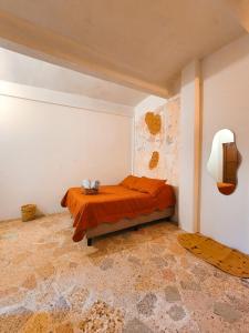 sypialnia z łóżkiem z pomarańczową kołdrą w obiekcie Habitaciones CASA BULE w mieście Oaxaca
