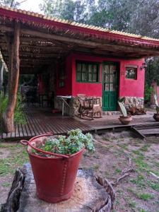 a red house with a potted plant in front of it at Cabañas spa el petrel in San Javier +1 photo